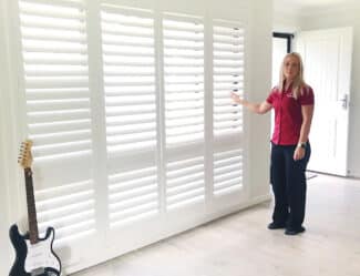 Woman Standing Beside Installed Plantation Shutters